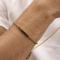 Pulsera GUESS Noir Para Hombre - Cadena Trenzada de Acero IP Dorado y Pieza Central con Parte Lacada en Negro | JUMB05109JWYGS